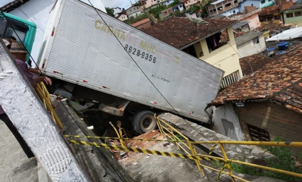 Caminhão derrapa, cai em ladeira e atinge casa