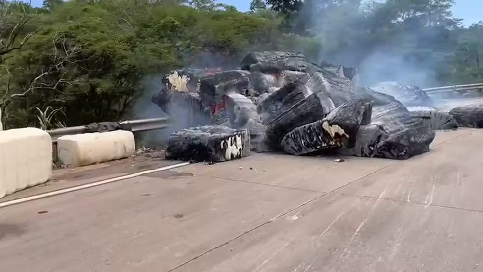 Carreta carregada com algodão tomba na pista e parte da carga pega fogo na BR-364