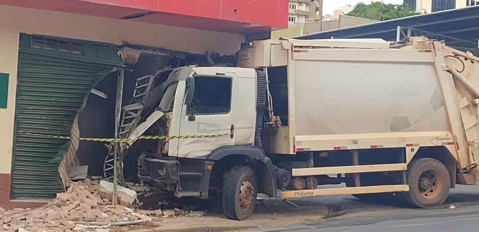 Caminhão de lixo da prefeitura perde controle de direção e atravessa muro de comércio em Cuiabá