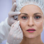 Close-up of doctor marking female patients face for cosmetic treatment